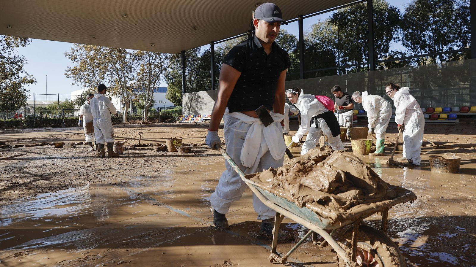 Voluntaris treballen en les labors de retirada de llot en el poliesportiu de Massanassa este dilluns.