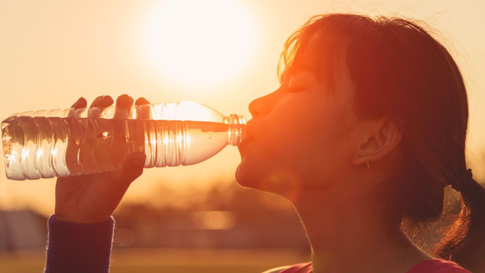 Una jove veu aigua per a refrescar-se durant un episodi d'altes temperatures