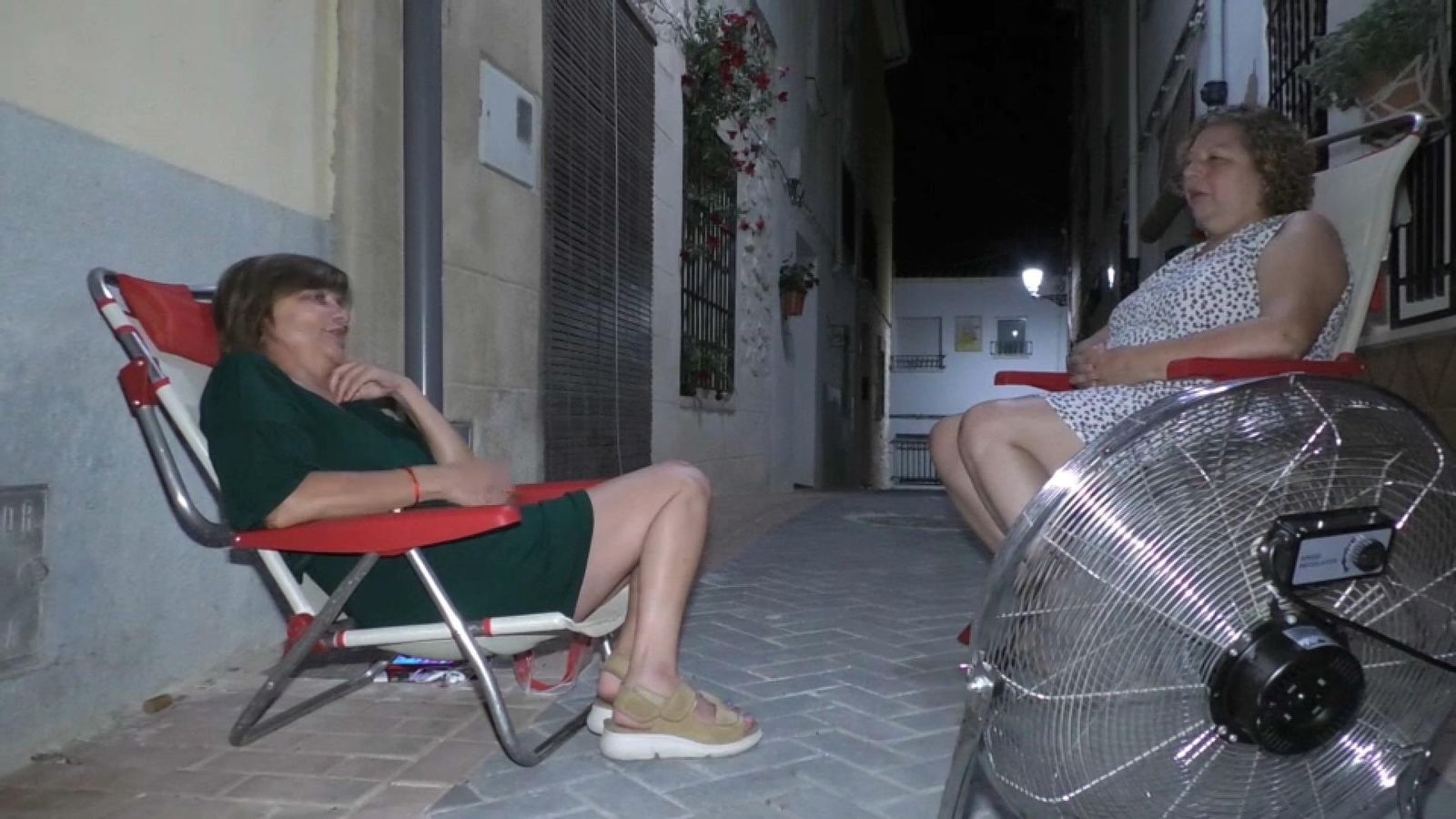 Dues veïnes tracten de combatre la calor a Gorga (el Comtat) a la fresca, amb l'ajuda d'un ventilador