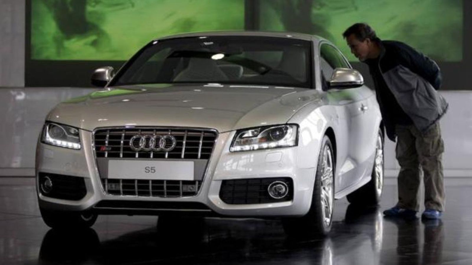 Un comprador mira un cotxe de luxe en un concessionari