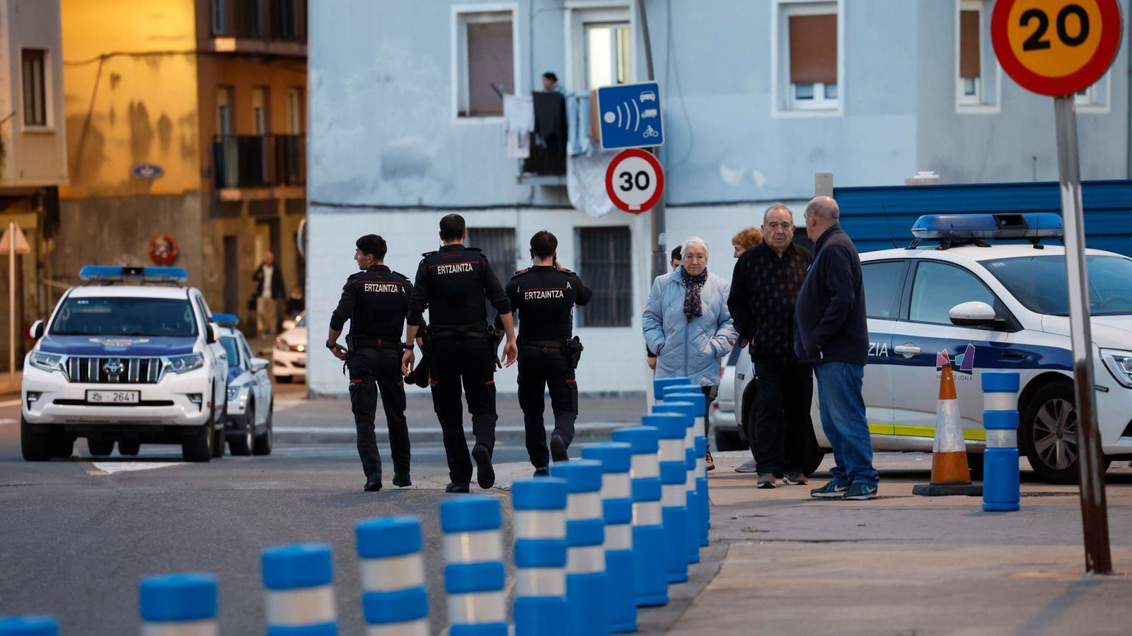 Agents de policia caminen per les immediacions de la vivenda de la víctima, on suposament va tindre lloc el crim