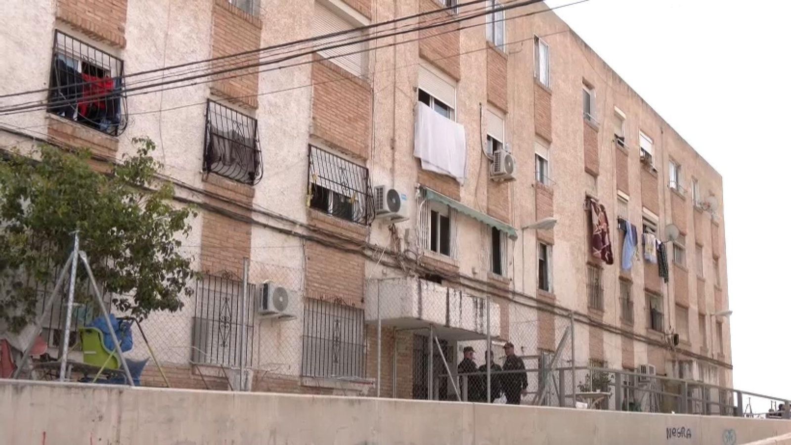 Diversos policies custodien l'entrada a l'edifici del barri alacantí de les Carolines on vivia la parella desnonada este dijous