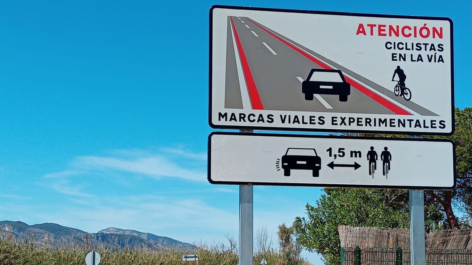 Un senyal que advertix de la presència de ciclistes en la via, senyalitzada en una franja roja per la Diputació de València