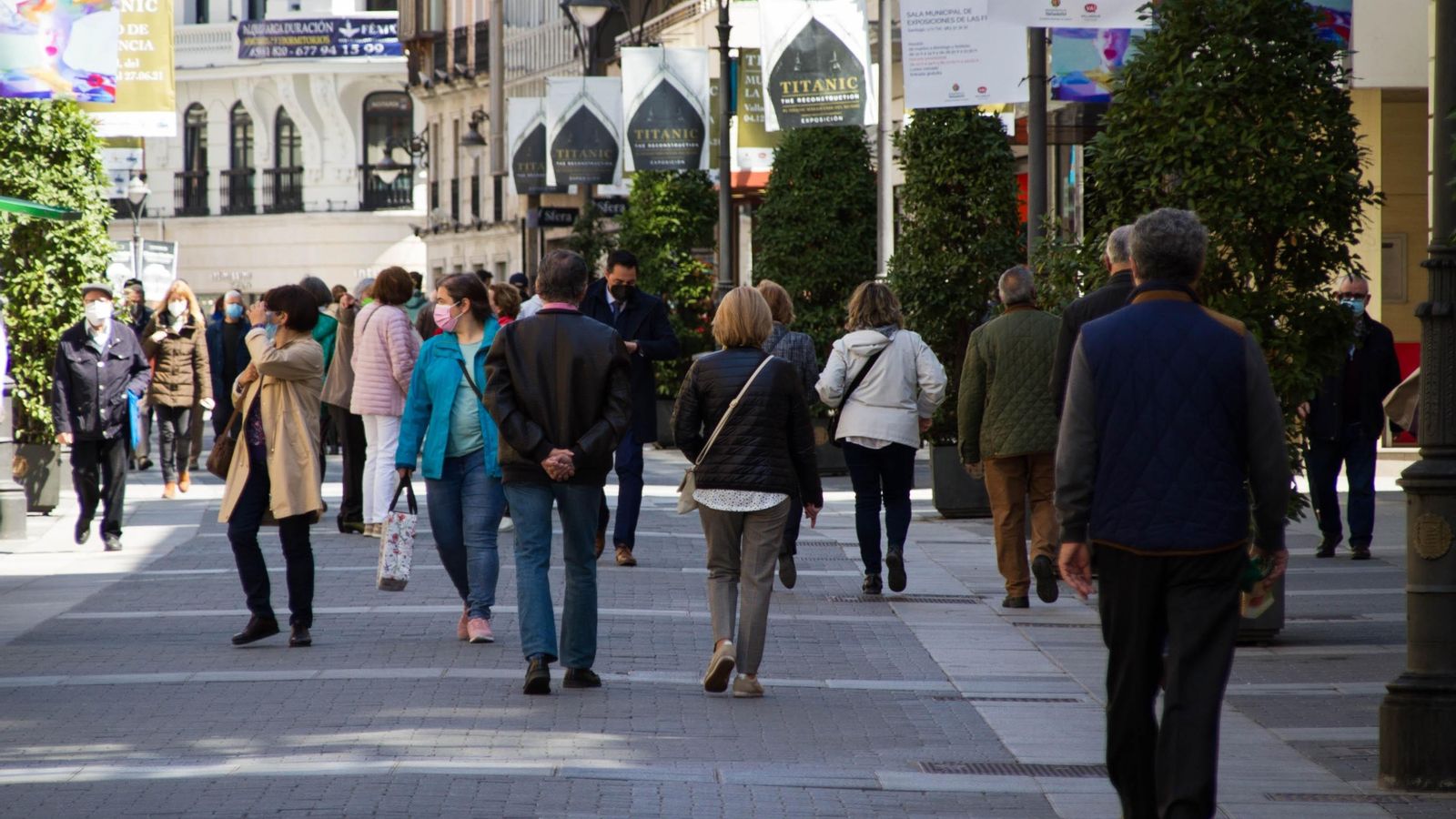 Diverses persones caminen per un carrer comercial