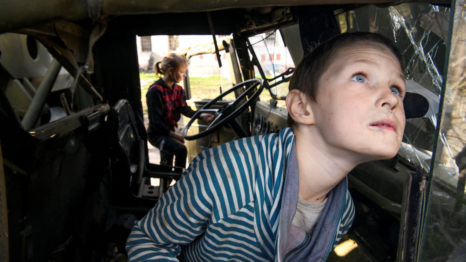 Un xiquet juga en un camió militar rus destruït al poble de Kolychivka, a la regió de Chernihiv, Ucraïna