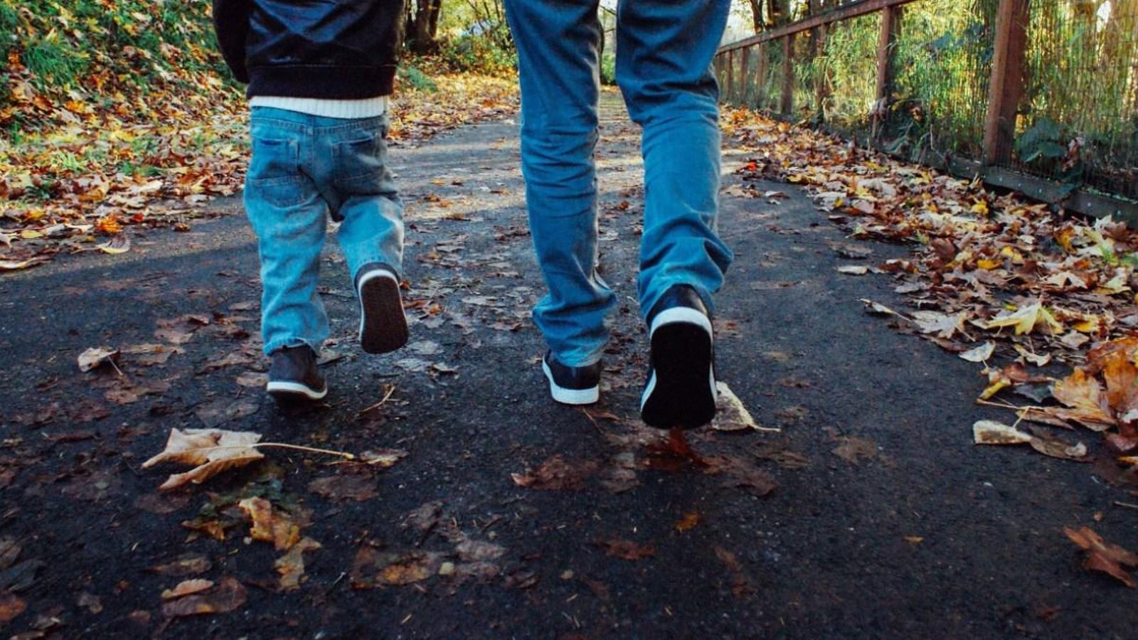 Un xiquet camina al costat d'un adult