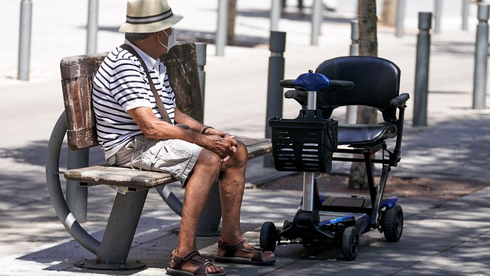 Un ancià amb màscara assegut en un banc, a 27 de juliol de 2021, a Madrid