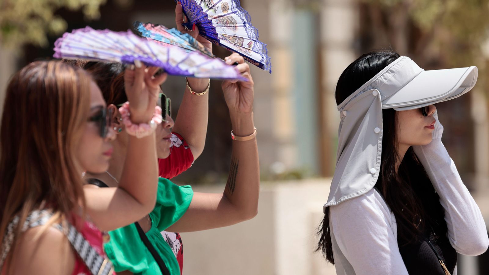 Diverses turisques es tapen amb ventalls per a protegir-se de la intensa calor