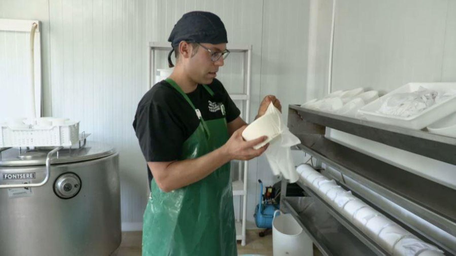 Jordi lleva la gasa a un formatge abans de ficar-lo en salmorra