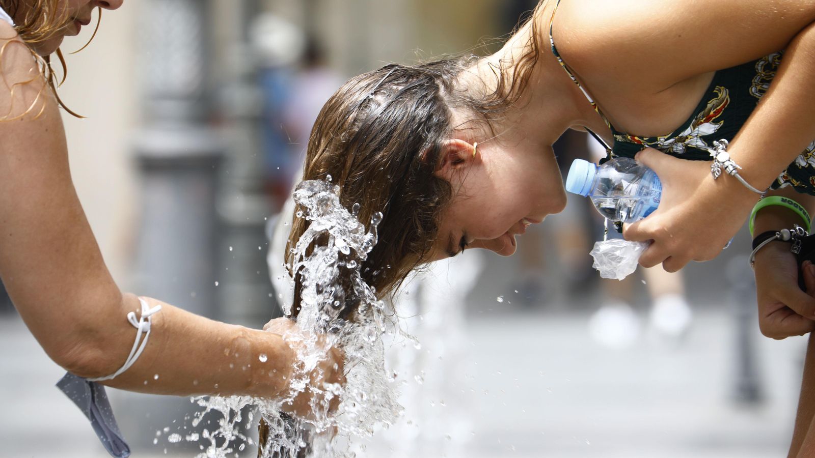 Una xica es refresca el cabell en una font
