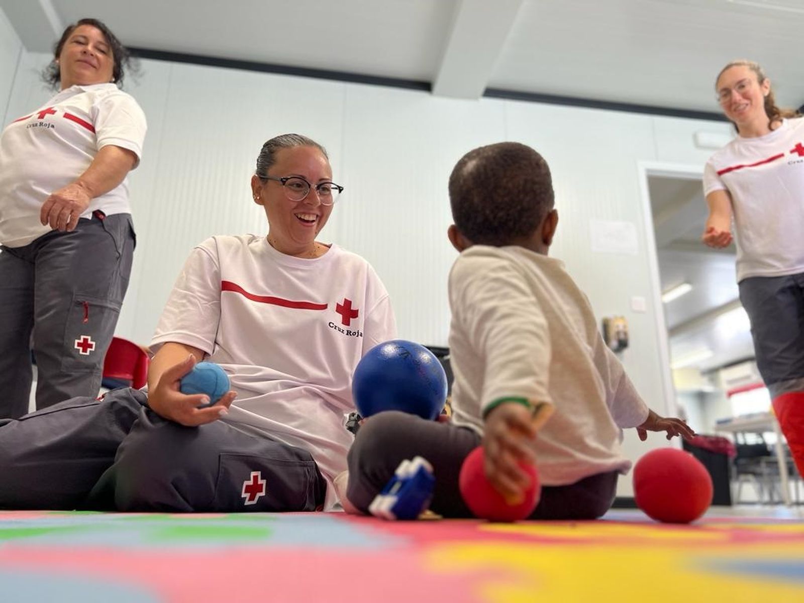 Voluntaris de Creu Roja amb un dels menors arribats aquest dilluns a les costes alacantines