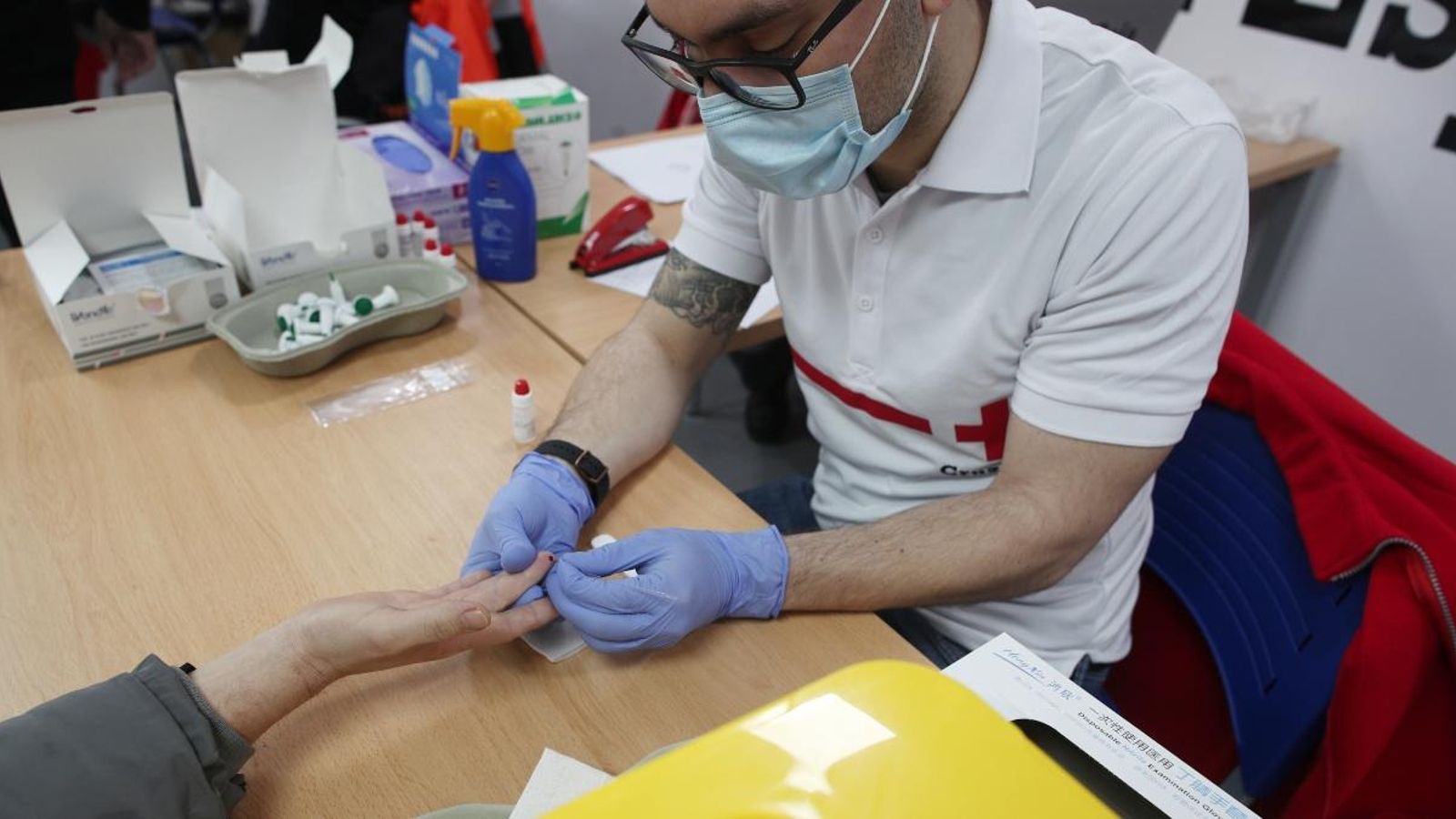 Un treballador de la Creu Roja realitza un test de Covid-19