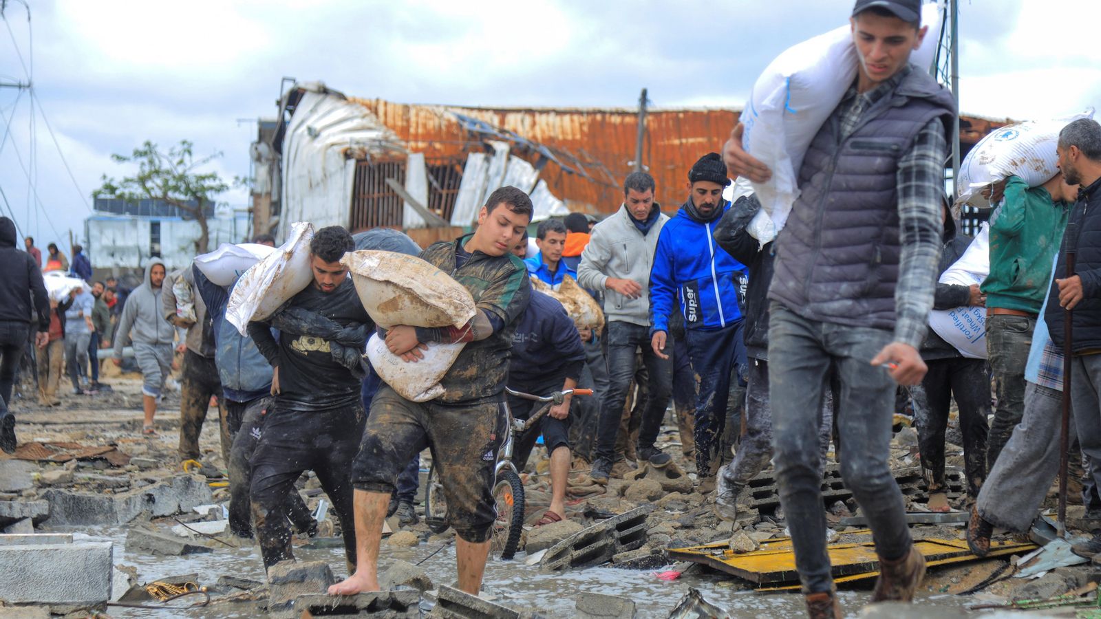 Un grup de palestins replega sacs de blat després d'una de les entregues humanitàries a l'UNRWA