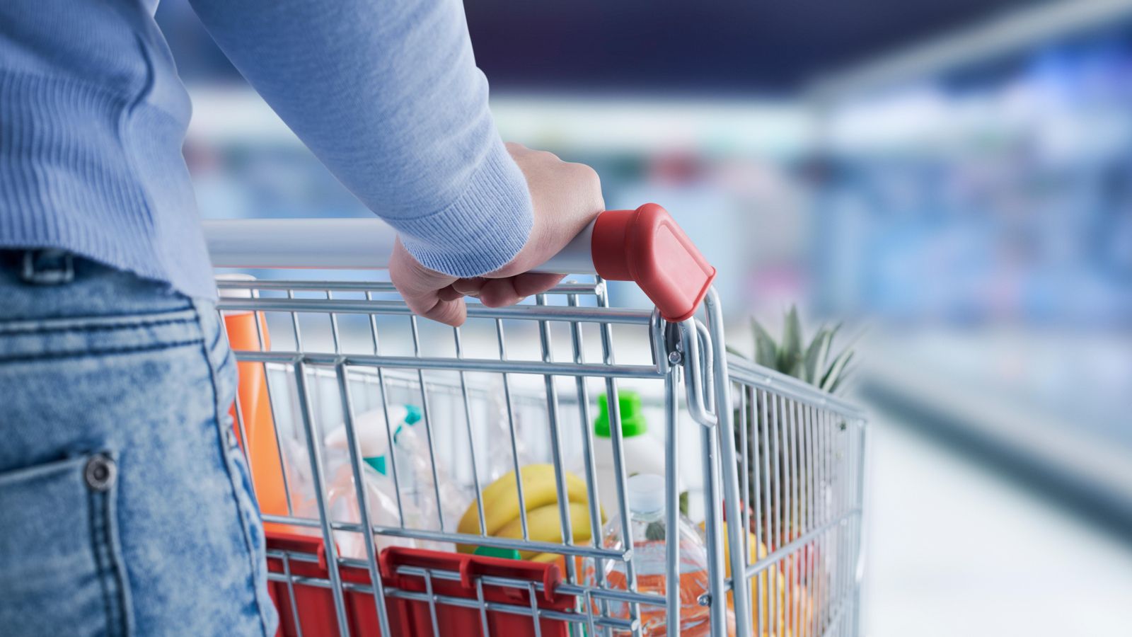 Una dona empenta un carret de la compra