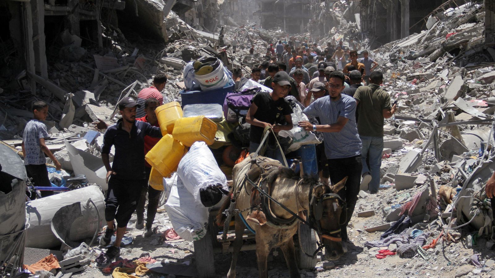 Una columna de palestins abandona els enderrocs del camp de Jabalai en busca d'aigua i aliments