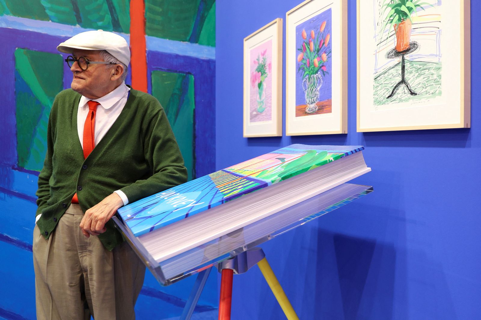 Hockney posant al costat d'algunes de les seues obres
