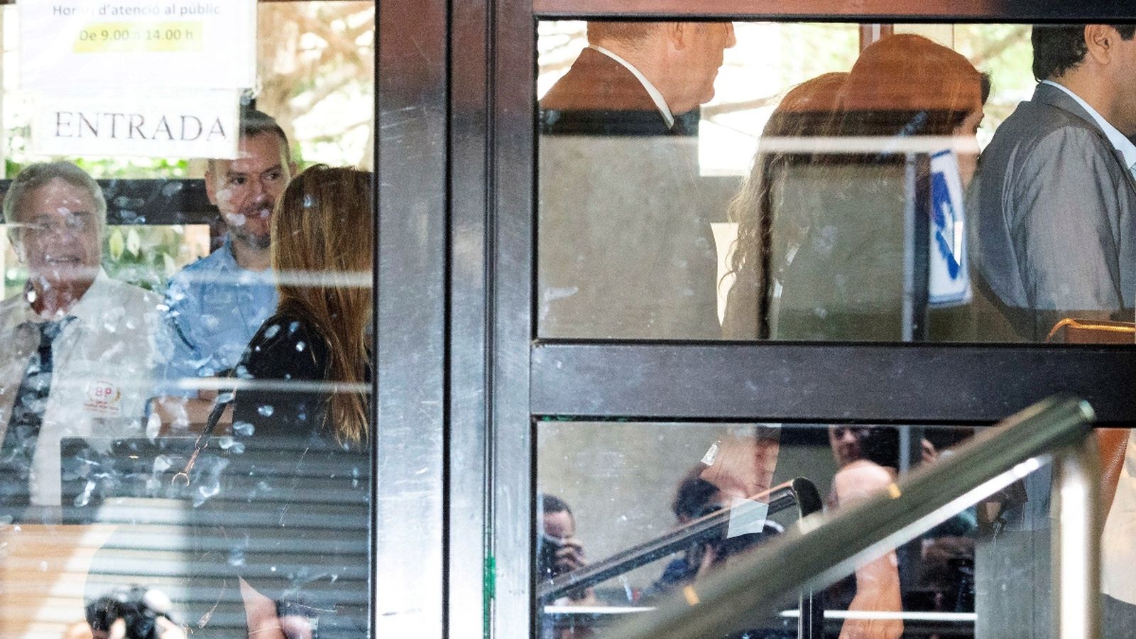 La cantant Shakira (al fons, tapada) ha eludit aquest dijous a la premsa que l'esperava a les portes del jutjat d'Esplugues,citada com investigada