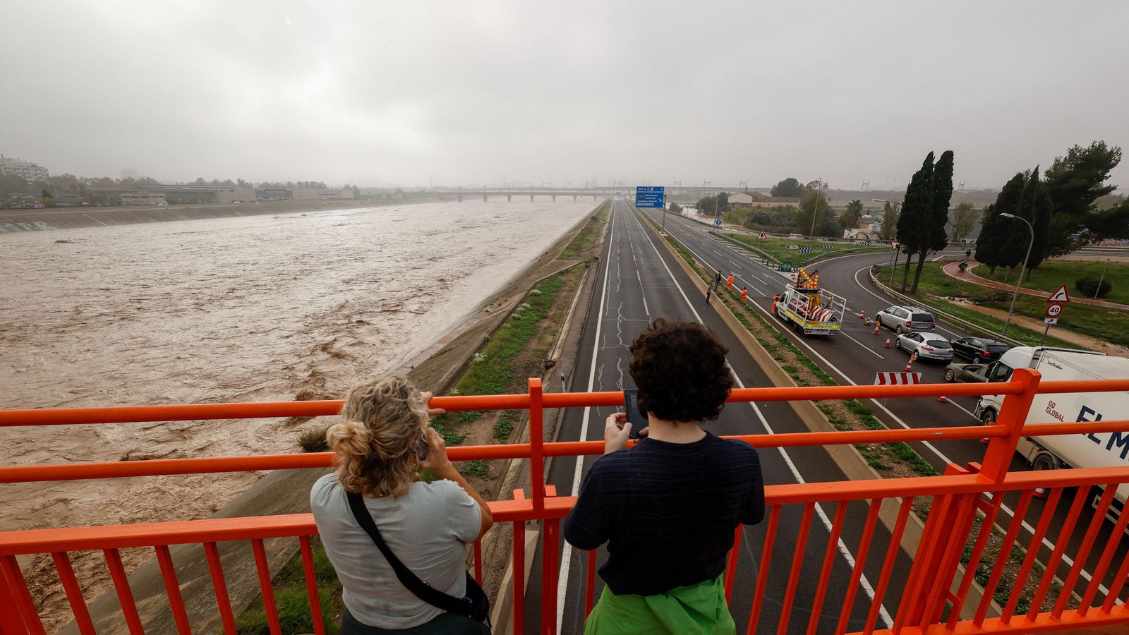 Dos dones aprecien el Turia, al seu pas per València i la V-30, després de les intenses pluges de dimarts