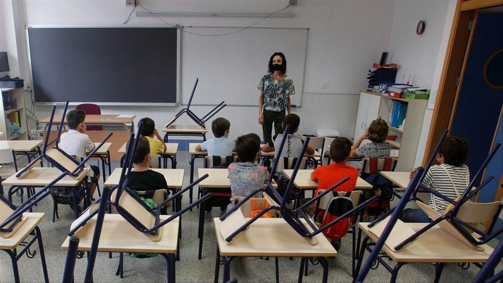 Imatge de recurs d'una aula amb taules buides per alumnes confinats