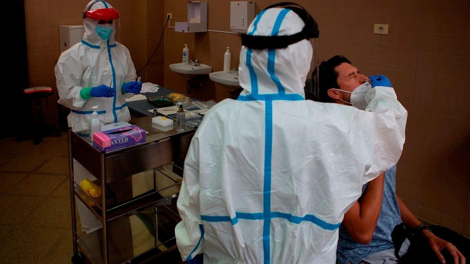 Sanitaris fan obtenen mostres d'un pacient per a fer-li la prova que identifica el coronavirus