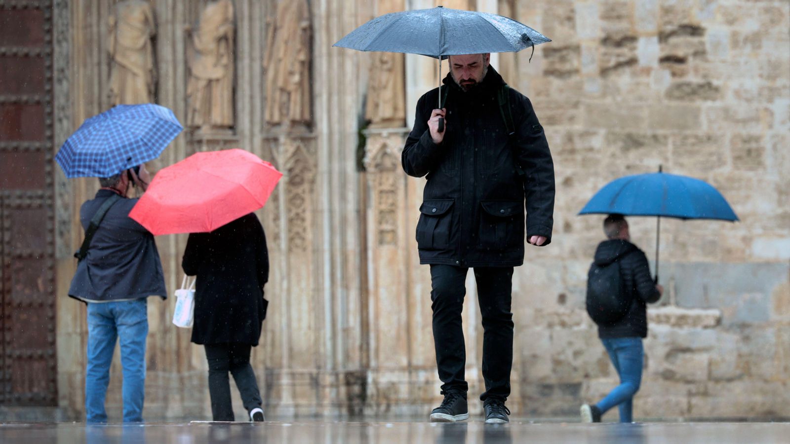 Diverses persones caminen amb paraigües a València, imatge d'arxiu Aquest dijous, primera jornada festiva al territori valencià, encara poden caure precipitacions en les comarques del sud del golf de València