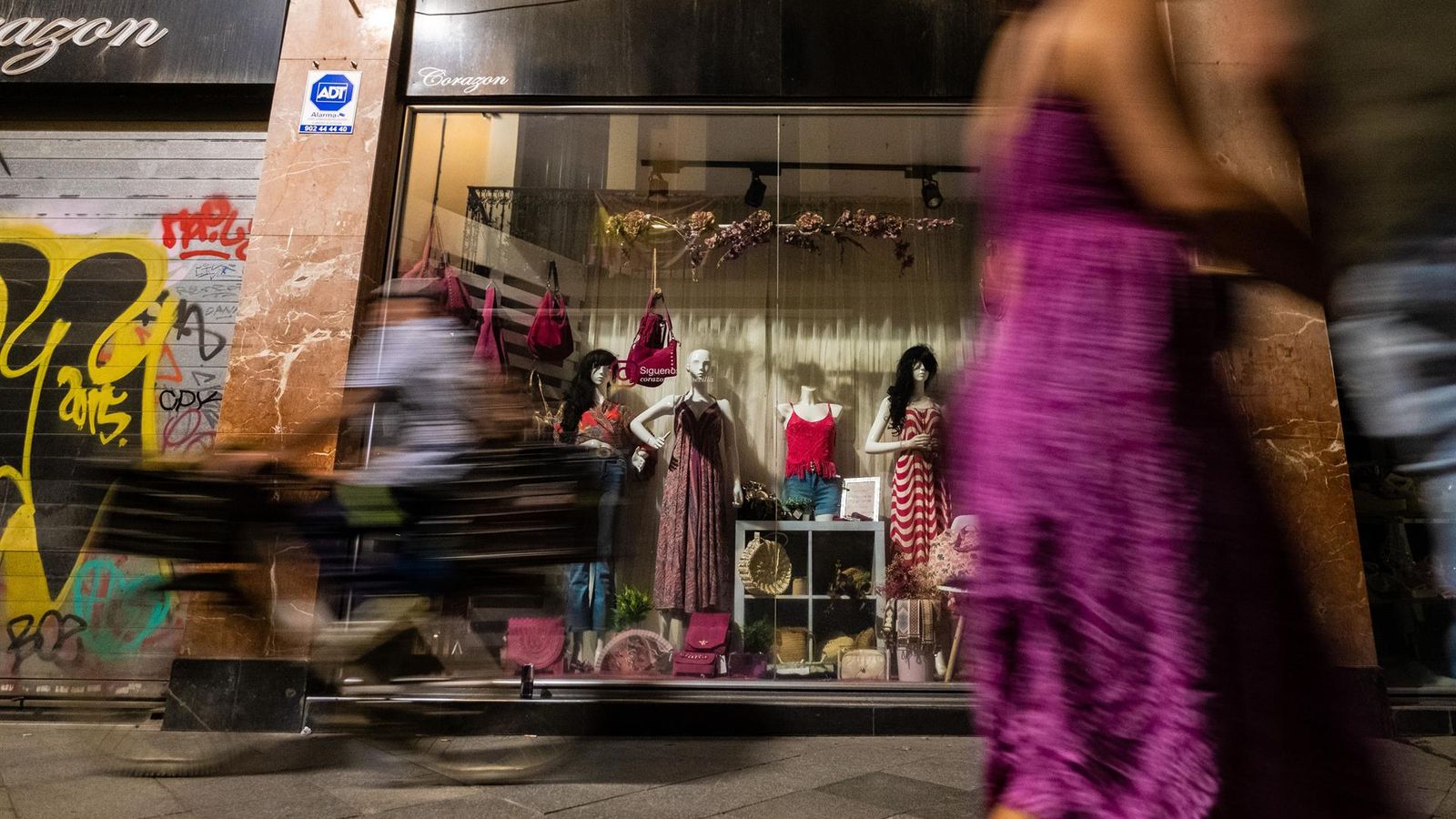 Una dona passa per davant d'un aparador sense llums