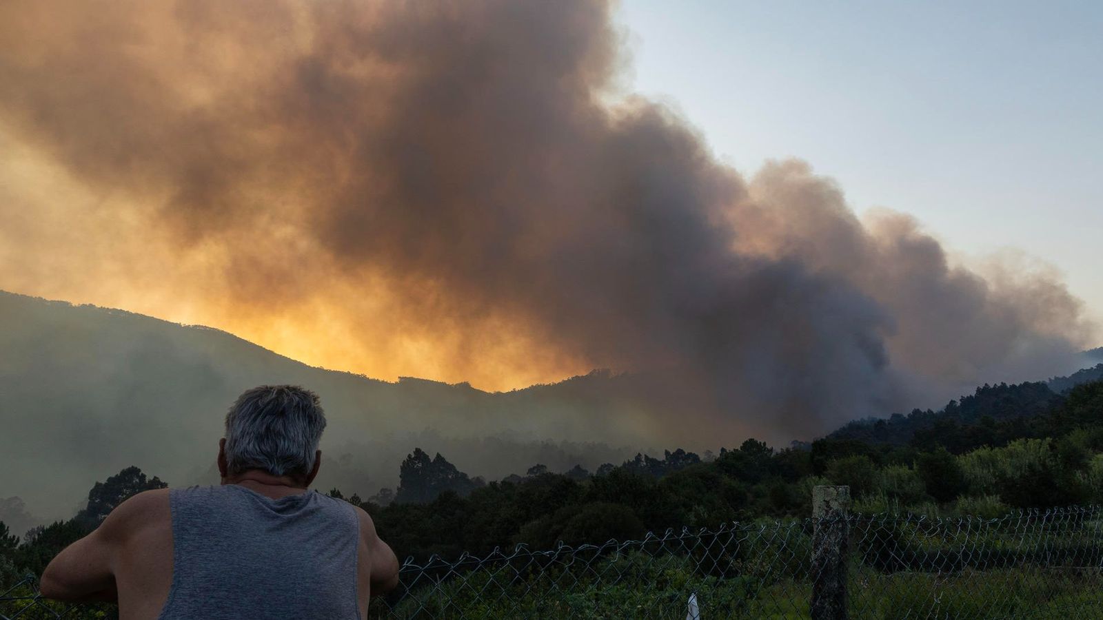 Un veí observa l'incendi de Vilaboa, prop del nucli de Vilar, a Galícia, que es va declarar este dijous a la vesprada