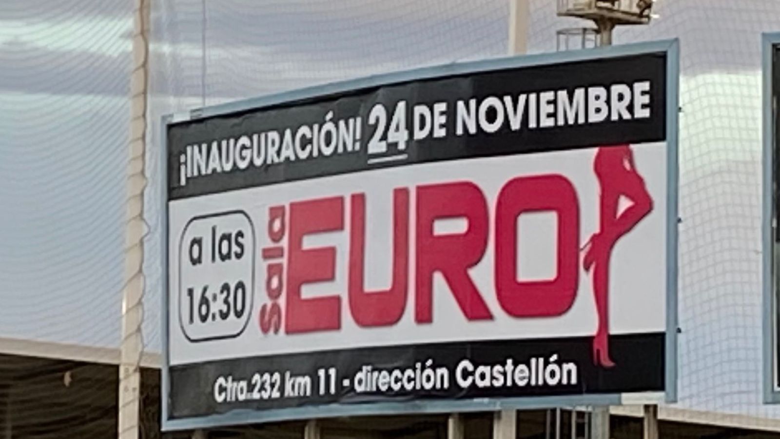 Publicitat d'un prostíbul en una tanca publicitària