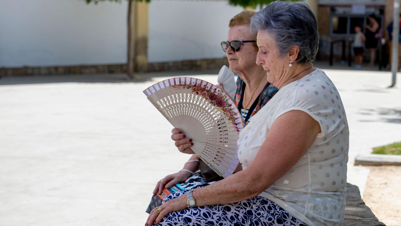Dues dones s'aventen en una ombra en una de les primeres jornades càlides que està deixant aquest juny