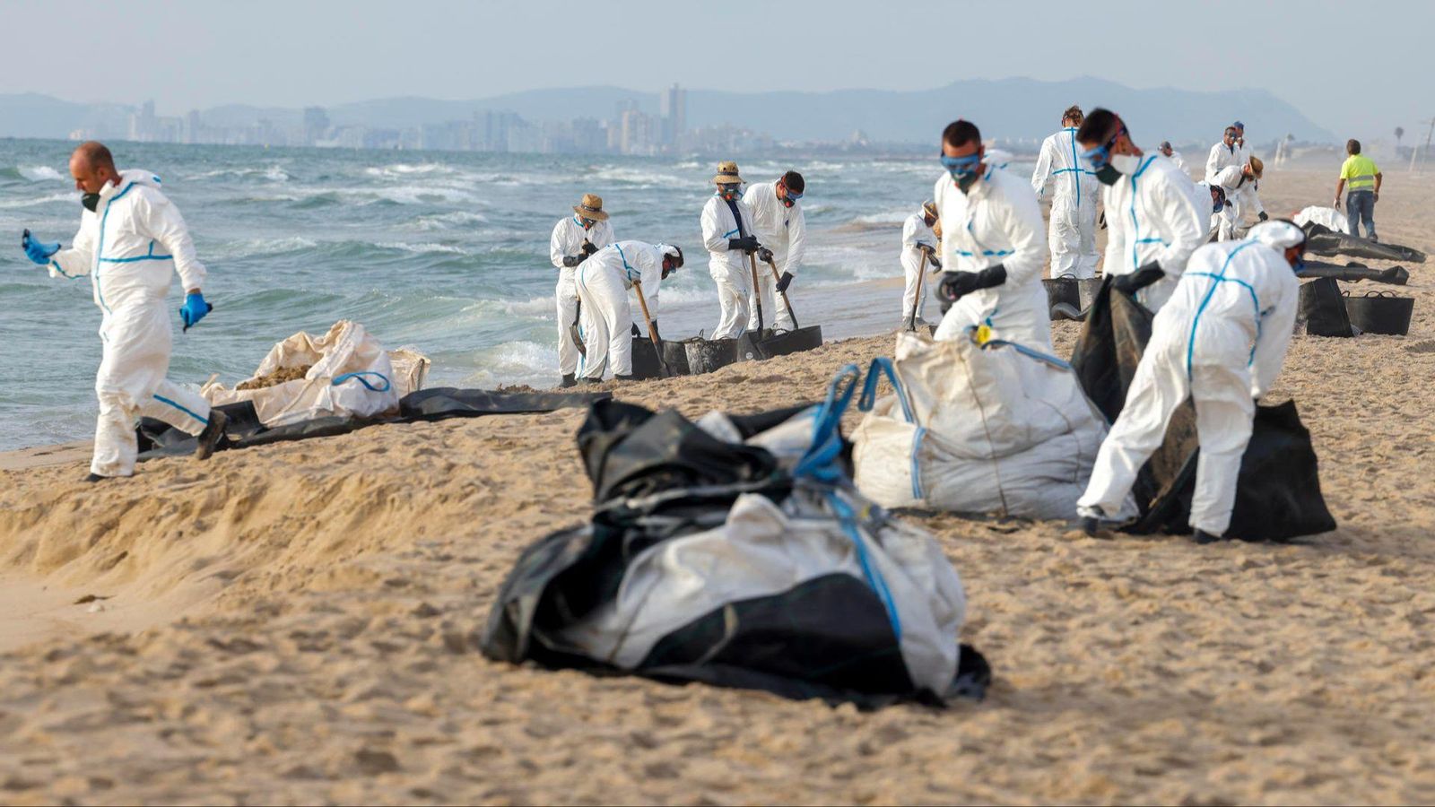 Una legió d'operaris que treballen, des de primera hora d'este dimecres, en la neteja de la substància negra que ha arribat fins a les platges del sud de València