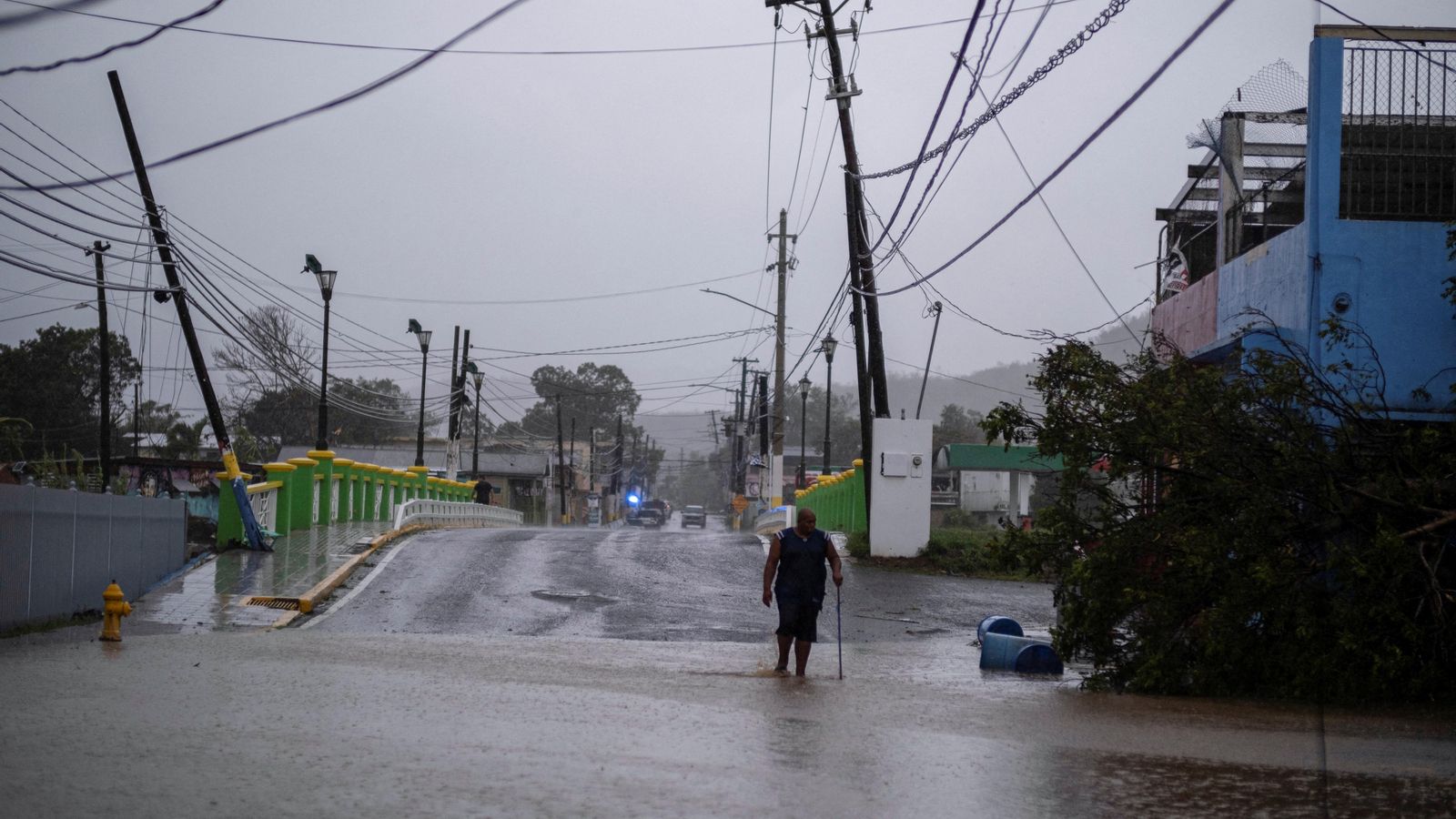 Una persona camina per Puerto Rico amb el tendall elèctric visiblement danyat hores després del pas de Fiona
