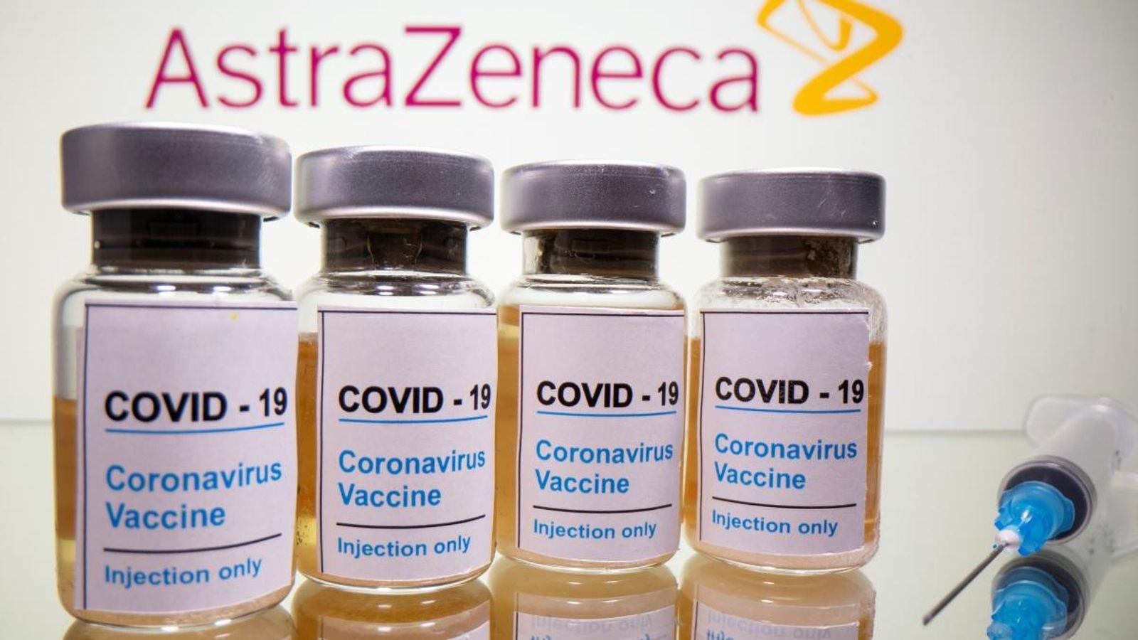 Dosis de les vacunes i una xeringa davant del logo d'AstraZeneca