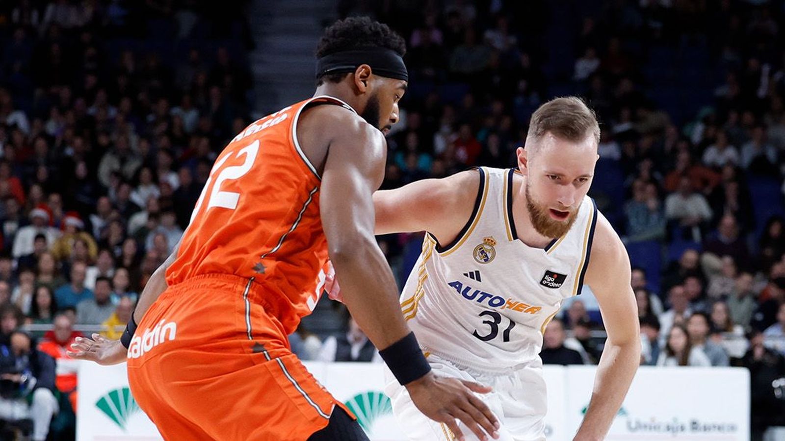 Una acció entre un jugador del Reial Madrid i un del València Basket