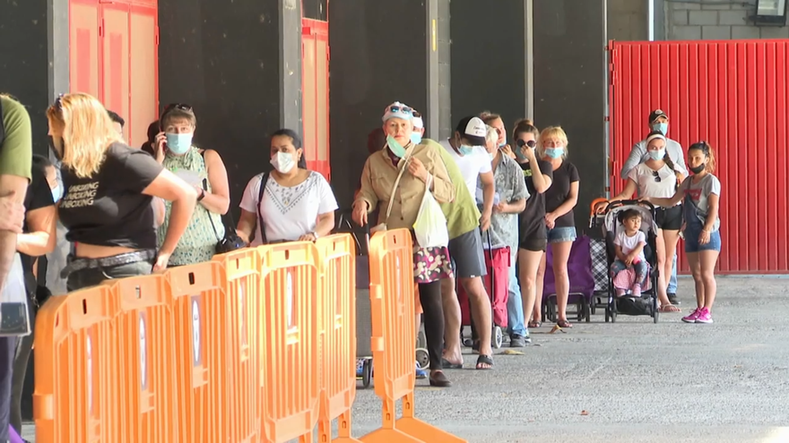 Un grup de persones esperen el torn durant un repartiment d'aliments a la ciutat de València