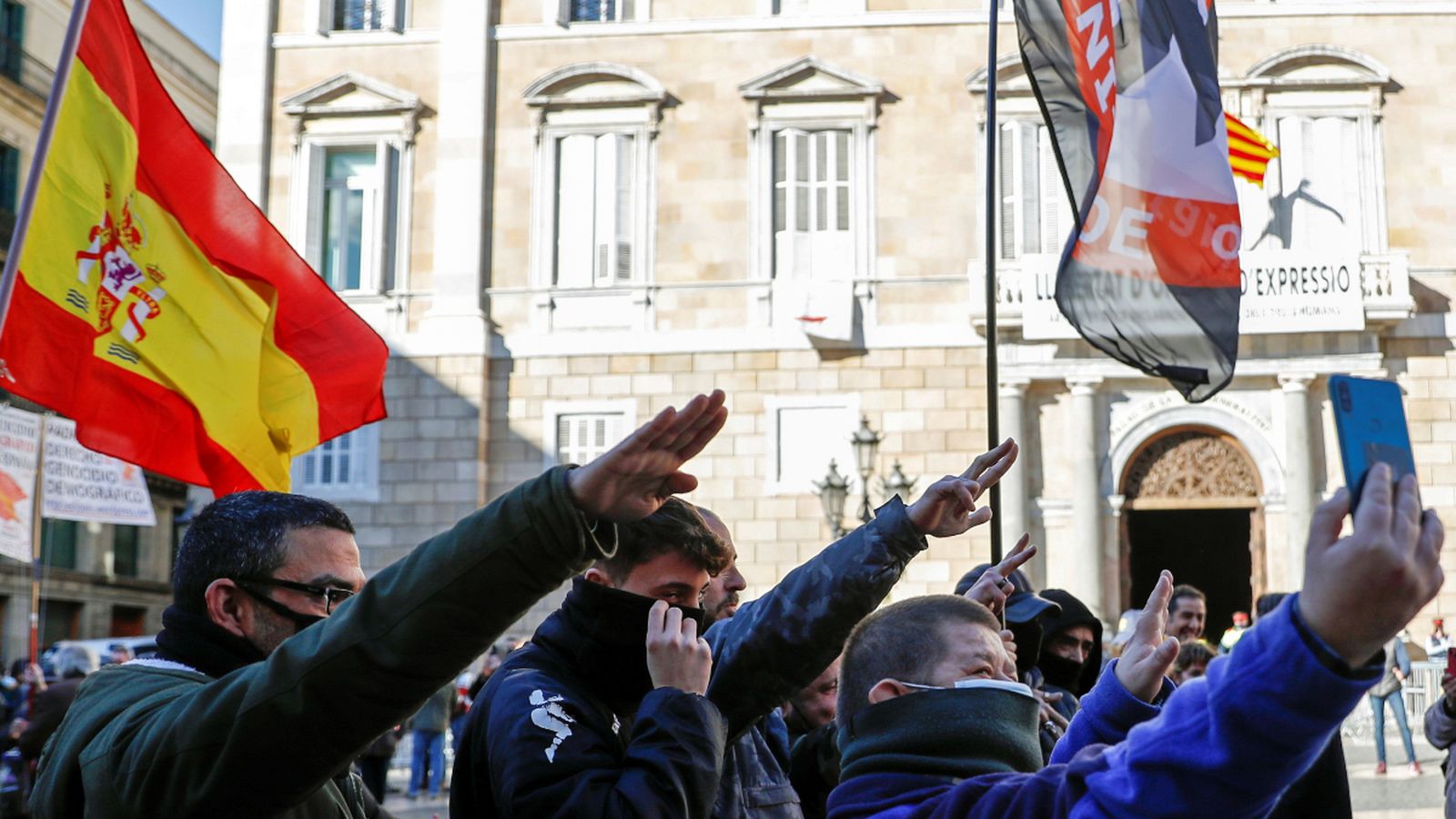 Manifestants fent una salutació feixista i amb una bandera d'un grup neonazi.
