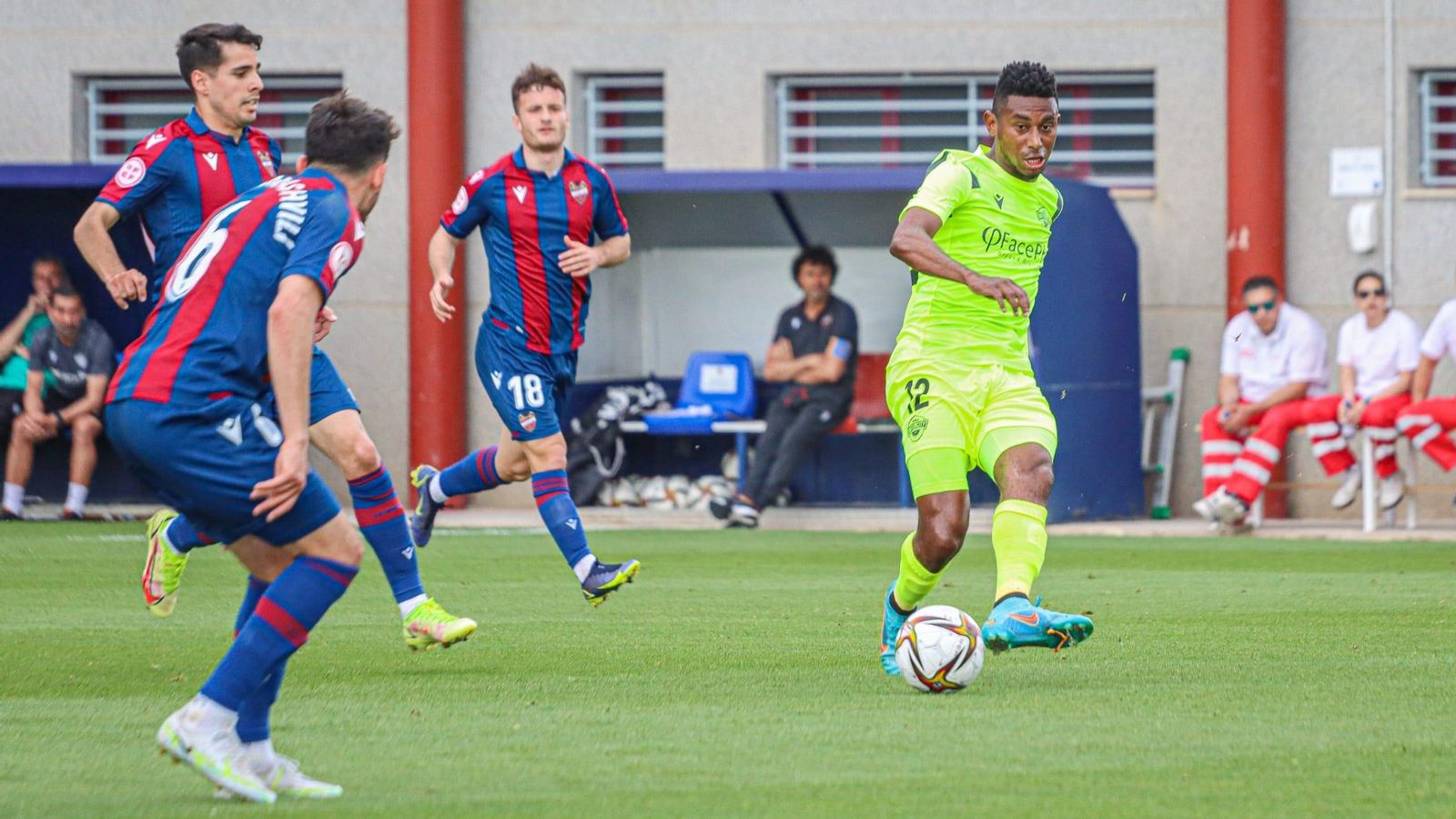 Josiel, de l'Intercity, fa una passada davant la mirada de jugadors de l'Atlètic Llevant