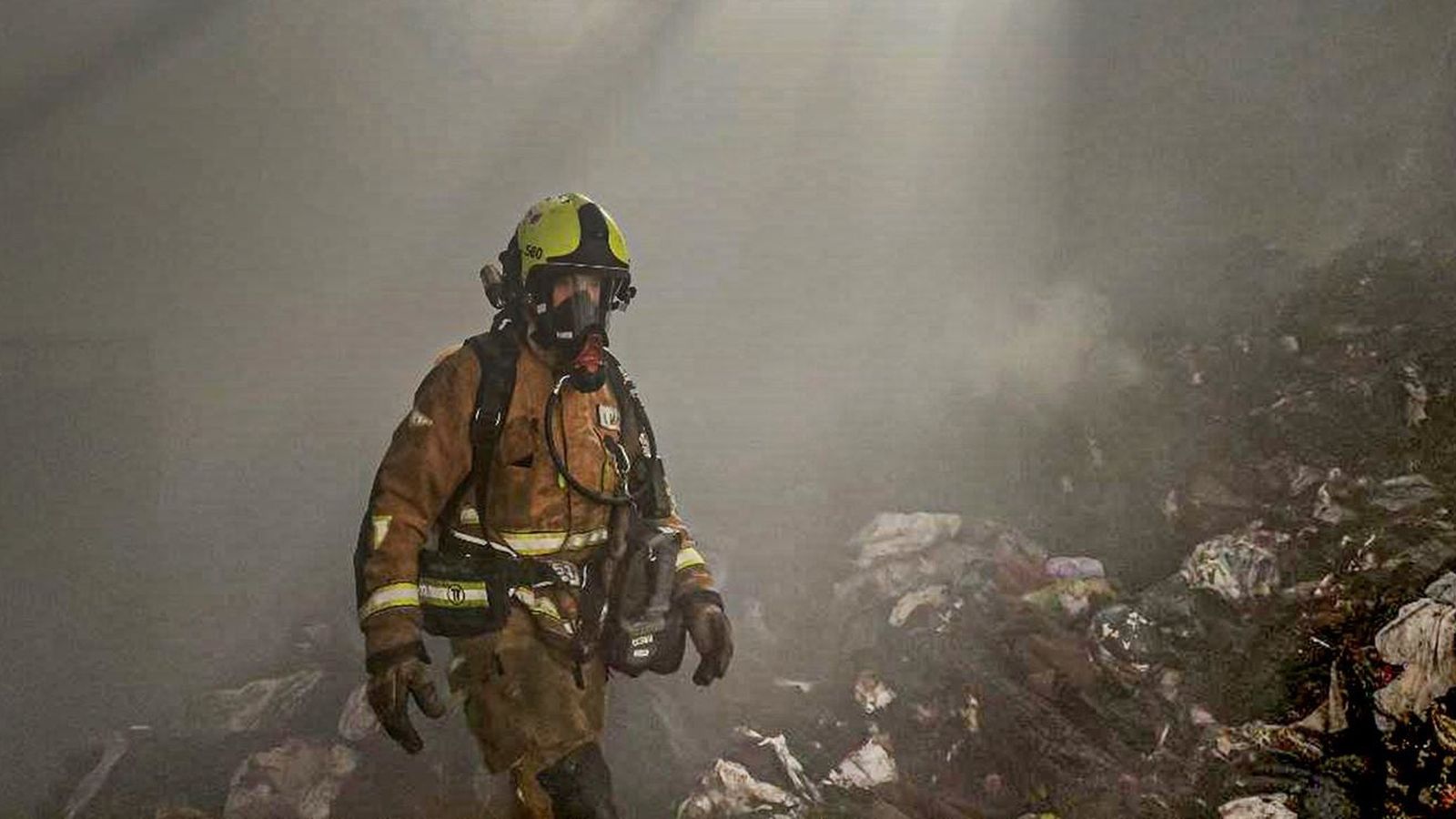 Un bomber treballant en la nau afectada per l'incendi