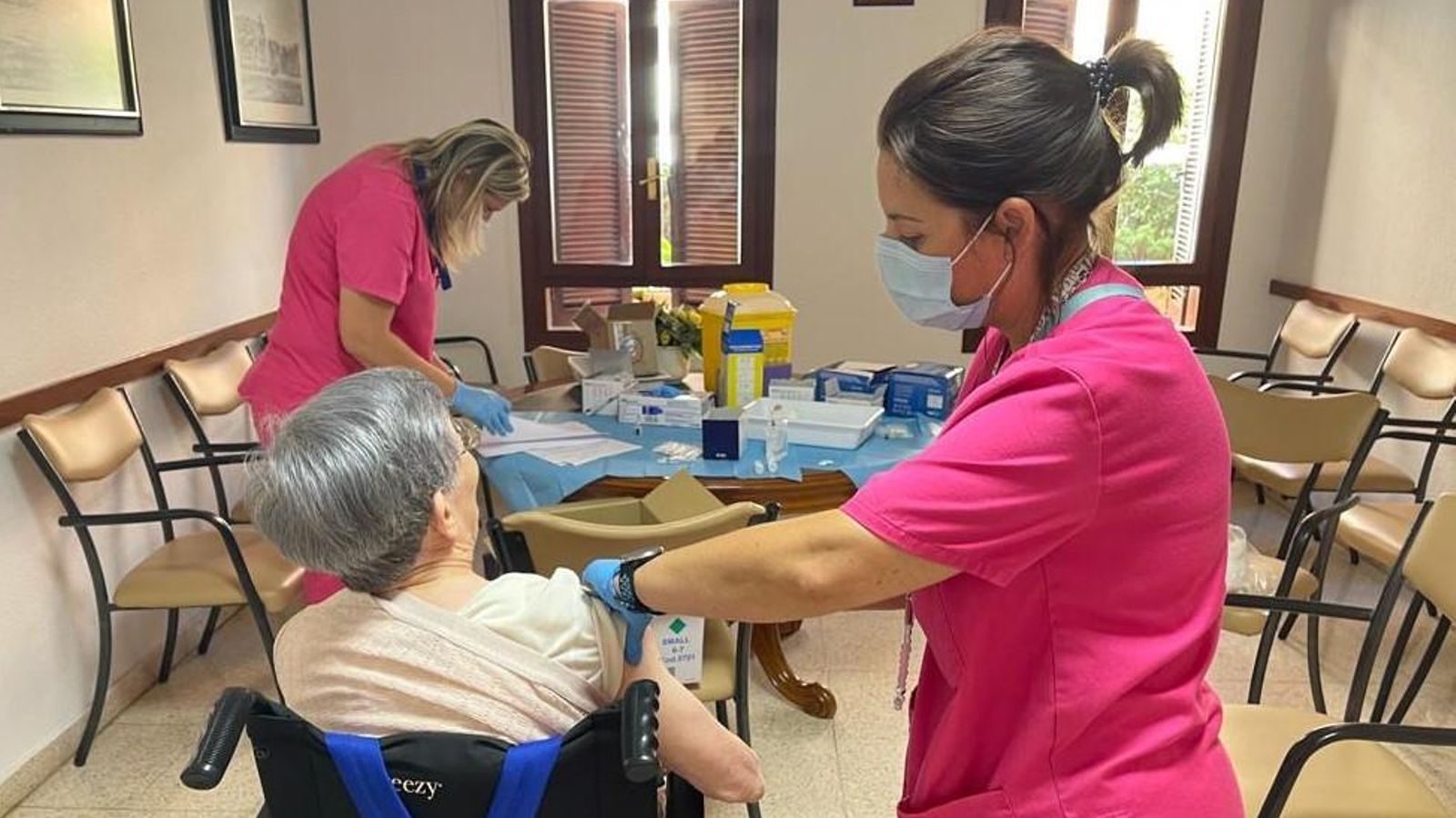Una infermera vacuna una dona major en una residència Una infermera vacuna una dona major a una residència