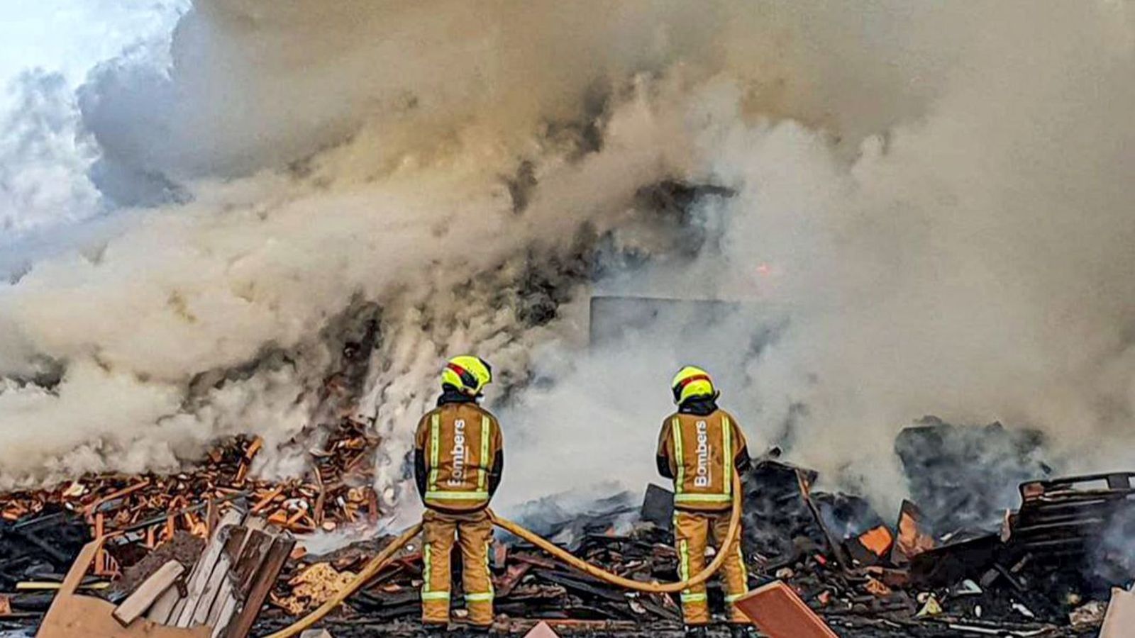 Dos dels bombers que treballen en l'extinció de la planta de residus de Villena