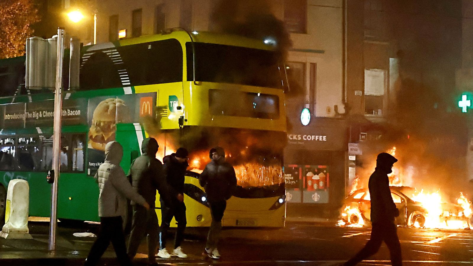 Un autobús crema durant una manifestació després d'un apunyalament múltiple a Dublín