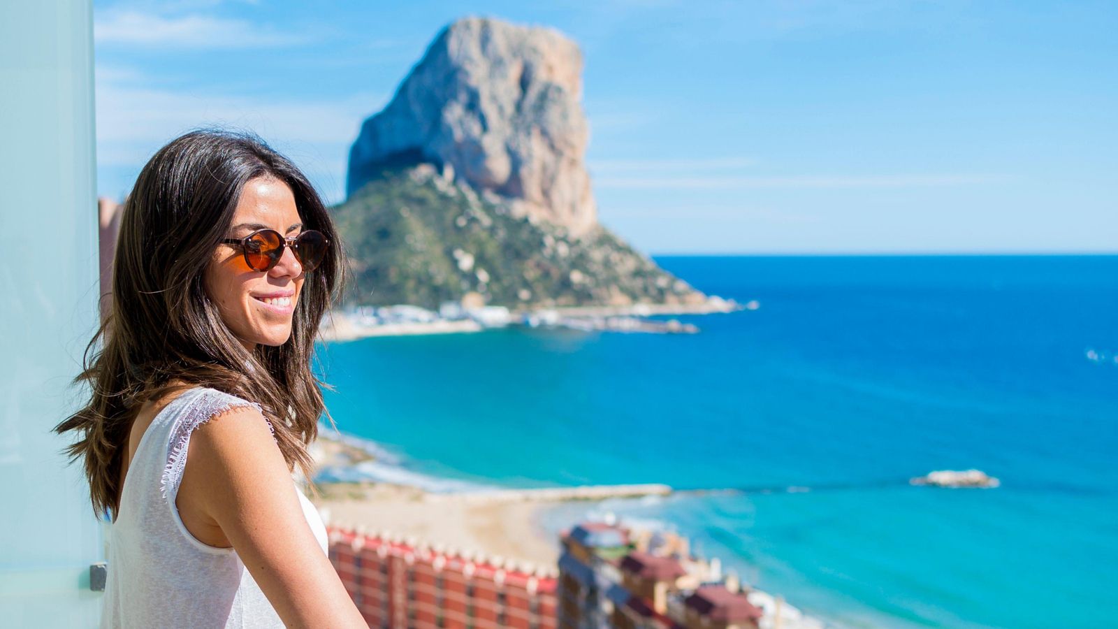 Una dona guaita des del balcó d'un hotel de Calp