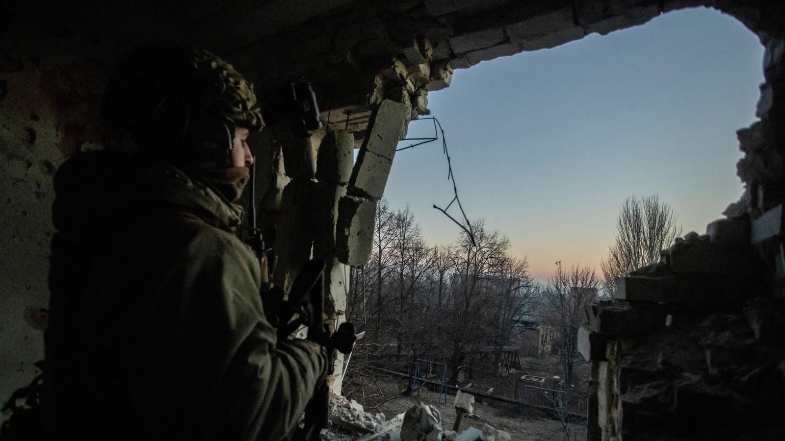 Un militar ucraïnés mira a través d'un edifici bombardejat a Bakhmut, regió de Donetsk, Ucraïna