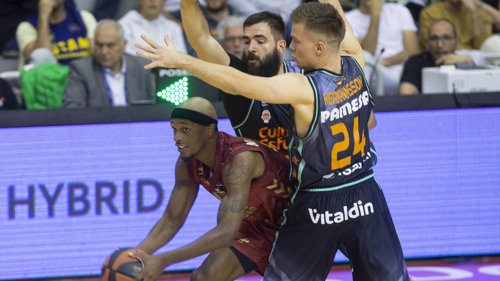 L'escorta de l'UCAM Murcia Thad MacFadden controla la pilota davant l'oposició de dos jugadors de València Basket Bojan Dubjevic i Martin Hermannsson durant el partit de la jornada vint-i-huit de la Lliga Endesa que han disputat aquest dimecres al Palau dels Esports de Múrcia.