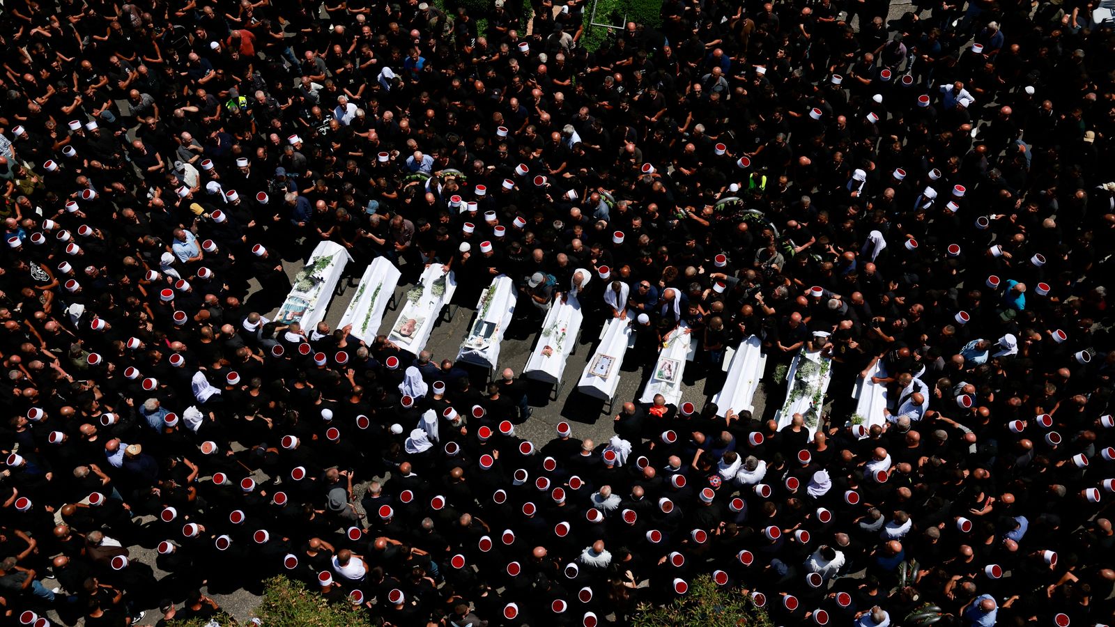 En imatge, el funeral pels dotze xiquets morts a l'aldea drusa de Majdal Shams després de l'impacte d'un coet llançat des del Líban