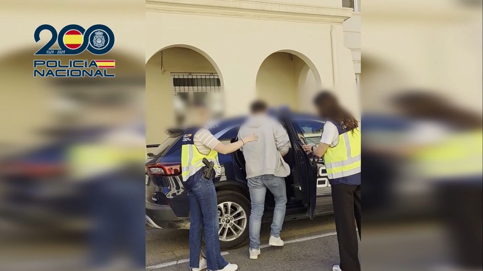 Dos agents custodien un dels detinguts en l'operació policial