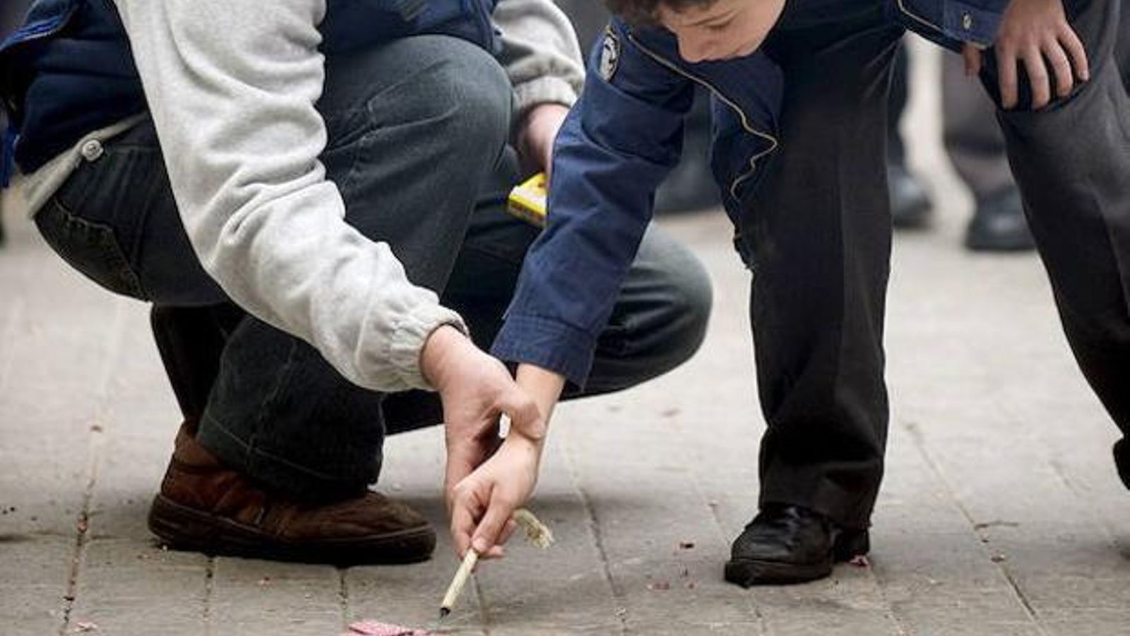 Un xiquet encén un petard ajudat pel seu pare