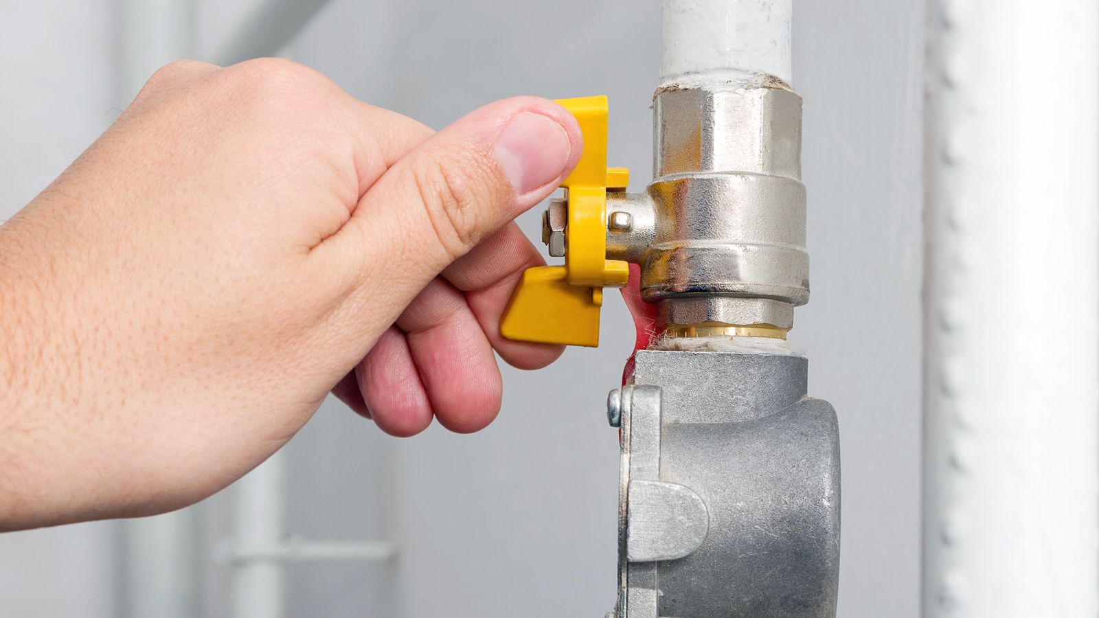 Una persona tanca una vàlvula de gas