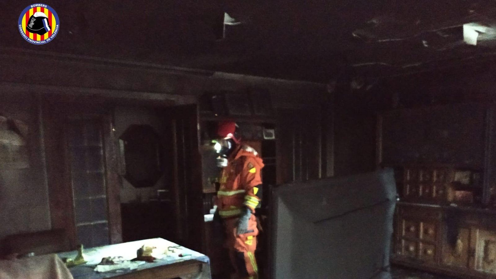 Un bomber revisa l'interior de la vivenda de Tavernes de la Valldigna on s'ha registrat l'incendi aquest dimarts de matí