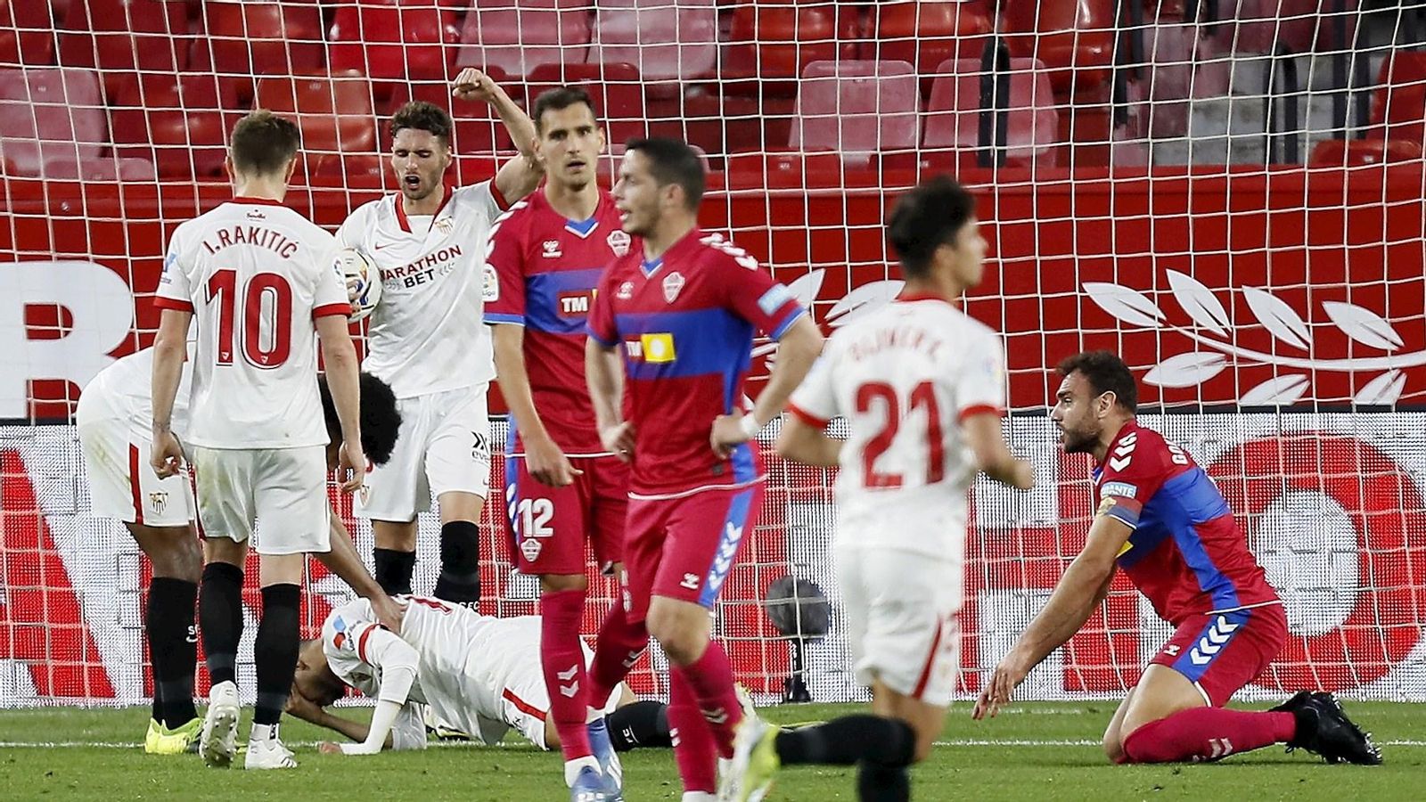 Els jugadors del Sevilla celebren un dels gols davant la frustració dels de l'Elx