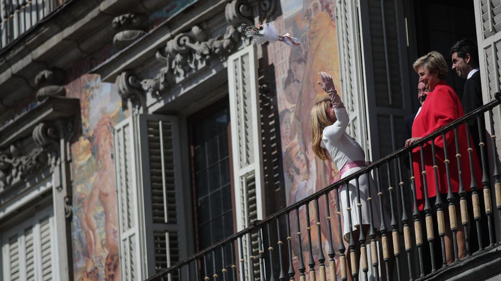 Una dona llança el ram des d'un balcó de la Plaza Mayor de Madrid després de casar-se